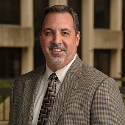 Man with graying goatee wearing a suit