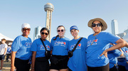 A group poses pre-walk with Reunion Tower as a backdrop.