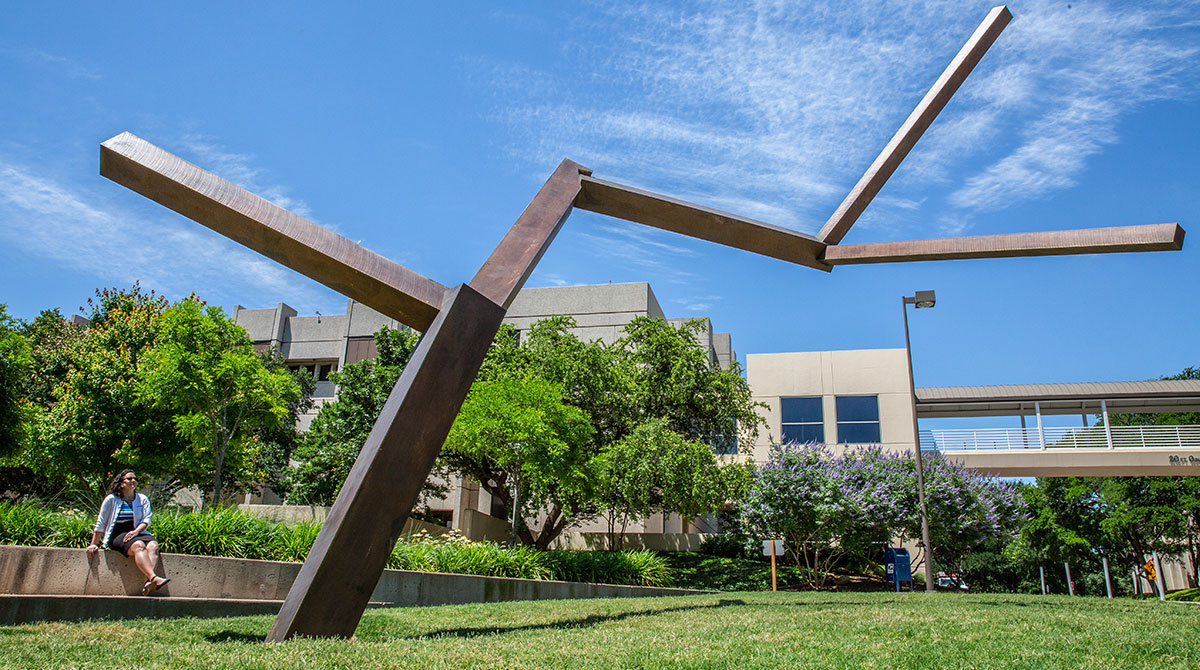 Shannon Luck seated adjacent to sculpture smiling