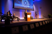 Dr. Daniel Costa (at lectern) gives remarks after receiving his Patient and Family Recognition Award, while Drs. Lee, Warner, and Podolsky watch nearby.