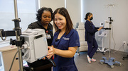 Adrian Richard (left), a Chemotherapy Scheduling Coordinator, and Lynne Dinh, a Clinical Staff Pharmacist, check infusion pumps while Mackenzie Hodge, CMOA, works in the background.