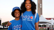 A mother and her son – the first to arrive – smile in front of Reunion Tower.