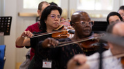 Dr. Feng (near back) led the effort to bring the WDO to Dallas. She has been playing the violin since the age of 6.