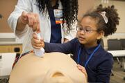 Lola Alexander learns how to use an ultrasound machine on a mannequin.