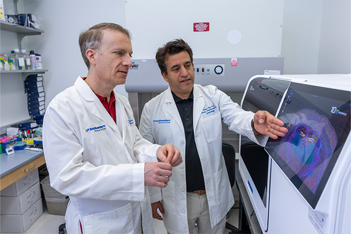 Scientist points out something to collegue on a large machine.