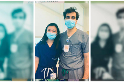 Photo of two people in masks and scrubs
