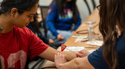 Students practice using a tendon hammer to elicit reflexes during the “How to do a physical exam” exercise.