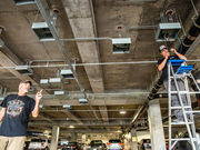 LED poles are wired under the roof of the parking garage.