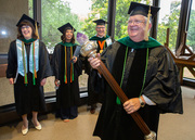 Dr. Gary Reed, Headmaster of the six Academic Colleges within UT Southwestern, enthusiastically leads the graduate procession inside Gooch Auditorium.