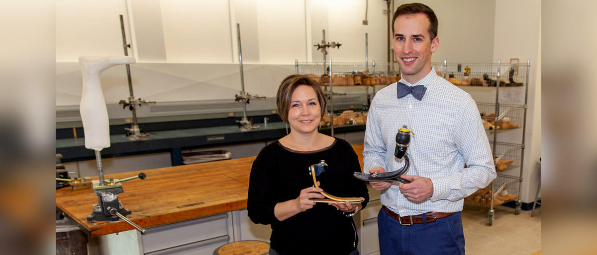 Man and woman in a lab holding prosthetics