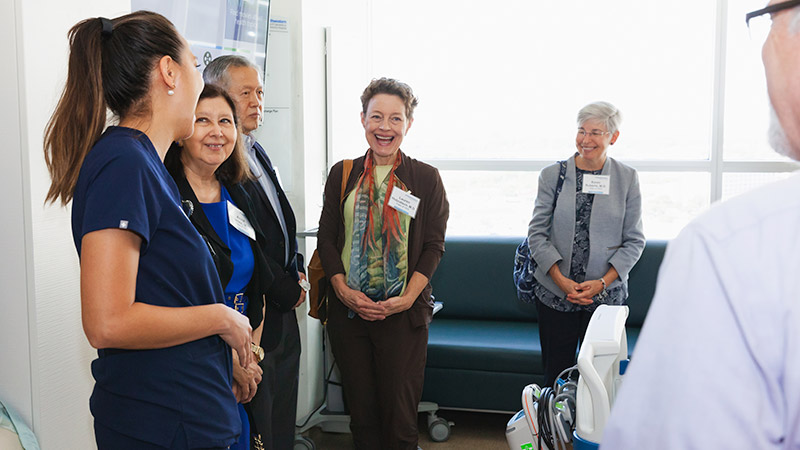 A group of people smiling and laughing, two women in the middle