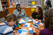 Graduate School students Anne Ojo (upper left) and Mitzy Cowdin (upper right) share a laugh while writing cards in a graduate lounge.