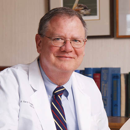 Man in lab coat with striped tie, glasses