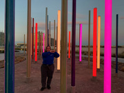 Christina Castillo, Guest and Patient Services, poses at the Forest of Light art installation at West Campus Building 3.