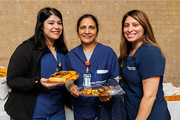 Three employees pose for a photo at the reception.