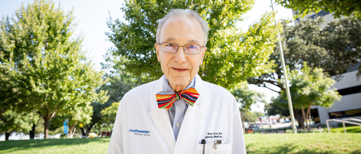 Older man in lab coat with a red bow tie