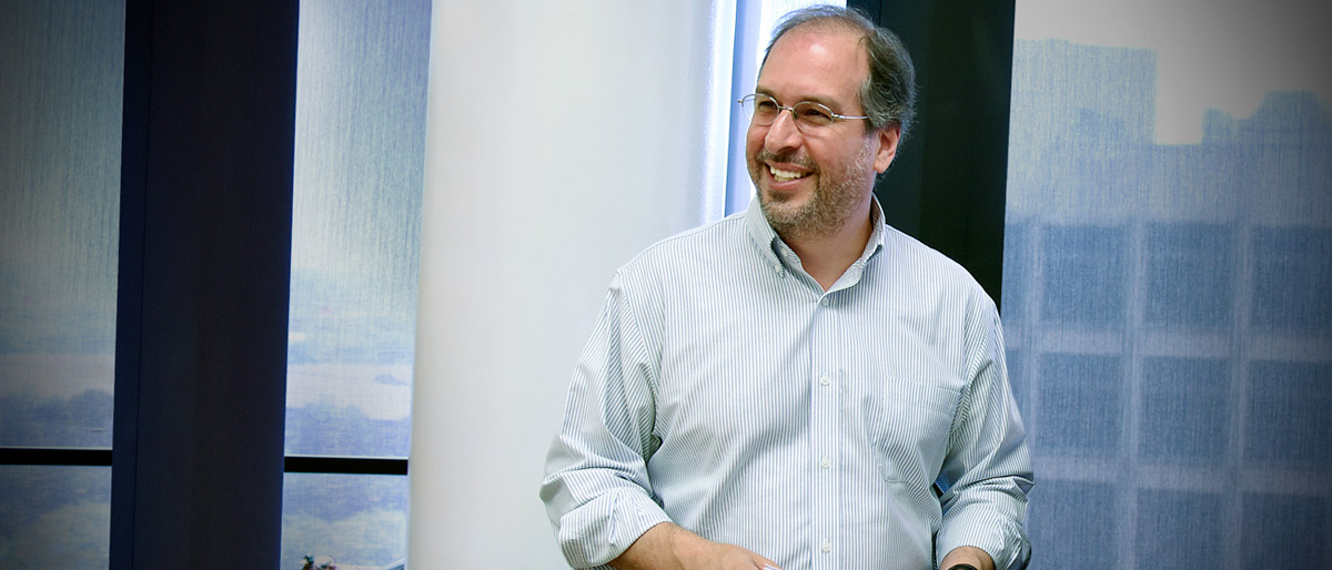 Man in buttoned white shirt with rolled up sleeves