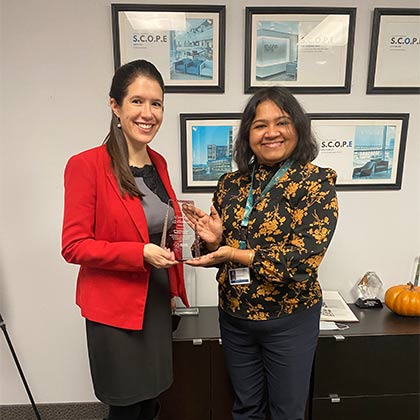 Two women holding D&I Award