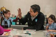 A student and Principal Roberto Gonzalez, M.D., share high-fives.