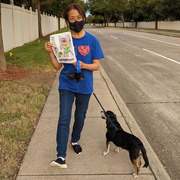 Multitasking Mary Barnes shows off her Heart Walk 2021 Coloring Book page while walking YoChan. (Winner, “I Love to Walk With My Pet”)