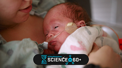 Baby with breathing tube being held by mom.