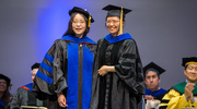 Zi Yang, M.S., Ph.D., poses for a photo after she is hooded by her mentor, Xuejun Gu, Ph.D., Adjunct Associate Professor of Radiation Oncology.