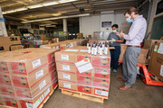 Materials Management Operation staffers Dorothy Whittington and Michael Rader survey a donation of 10,000 bottles of hand sanitizer given by Mary Kay.