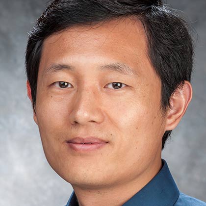 Man with dark hair and blue collared shirt