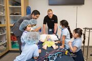 Mannequins at the Sim Center come in all shapes and sizes. Here, students help “heal” a child mannequin.