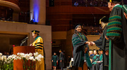 Harshitha Balla, M.D., accepts her diploma as W. P. Andrew Lee, M.D., Executive Vice President for Academic Affairs, Provost, and Dean of the Medical School, left, announces the names of graduates.