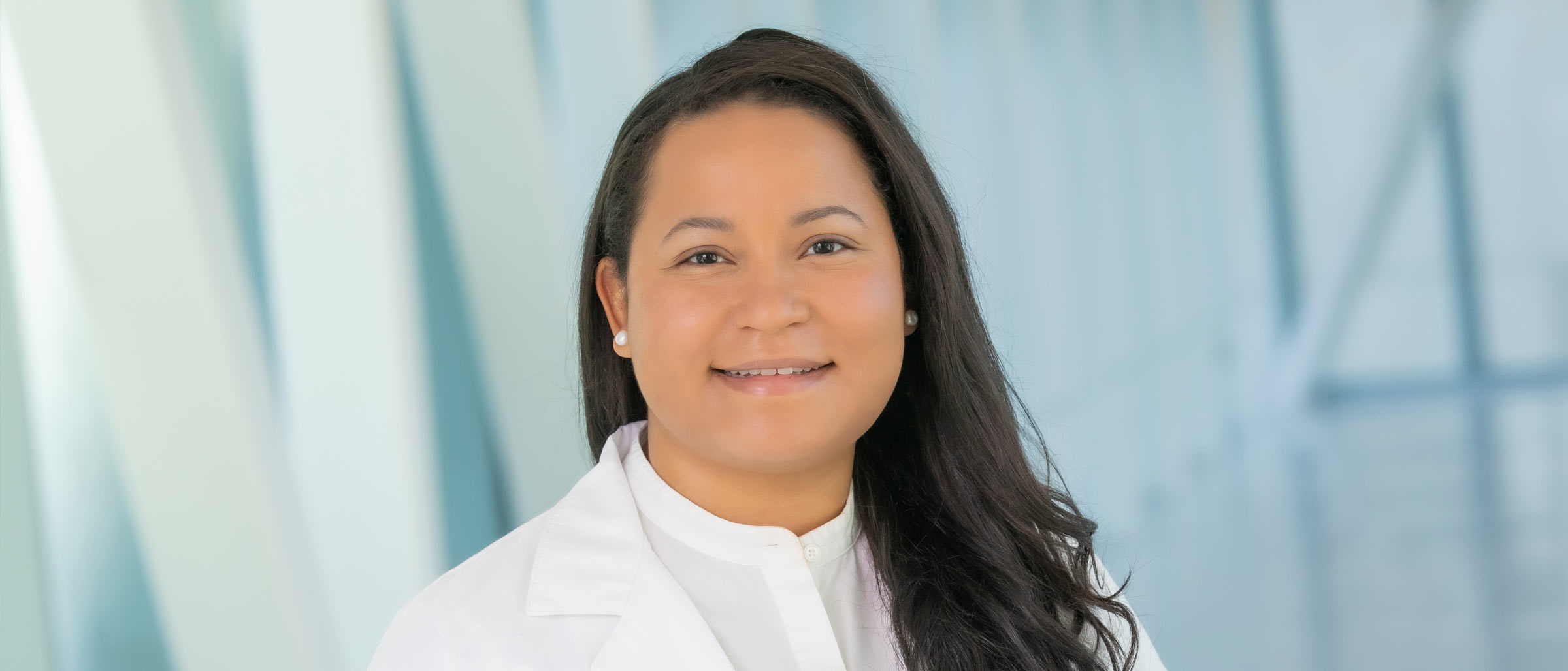 Woman with black hair, white shirt, wearing lab coat