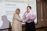 Vice President of Human Resources Janelle Browne presents Glenn Katz a certificate for his artwork.