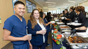 Clinical Research Coordinator Peter Gales (left) and Program Manager in Clinical Research Riley Martin line up for barbecue chicken.