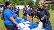 A staff member from the Harold C. Simmons Comprehensive Cancer Center engages an attendee to promote cancer awareness.