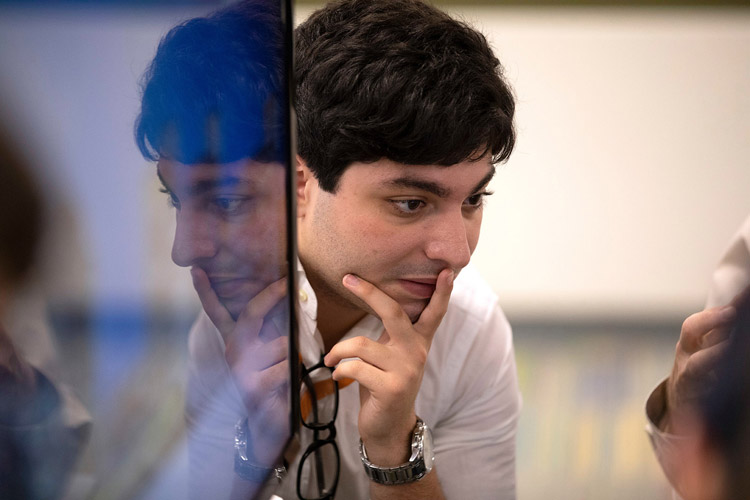 Man with hands on face listening to colleague