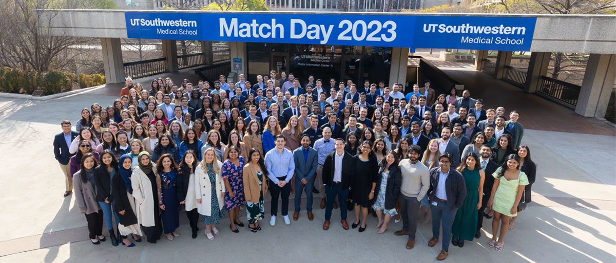 large cluster of students around match day sign