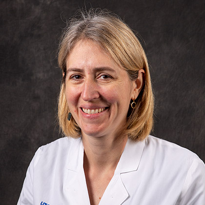 Woman with shoulder-length blond hair, wearing white lab coat