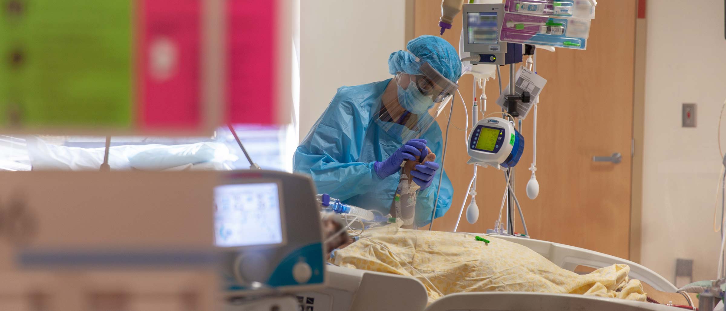 Person in medical gown, face shield, and mask treating patient