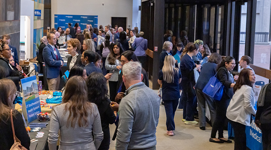 crowd stands and looks at tables before entering Gooch auditorium event