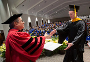 Andrew Nabasny, master of clinical rehabilitation counseling, accepts his diploma from UTSW President Dr. Daniel K. Podolsky.