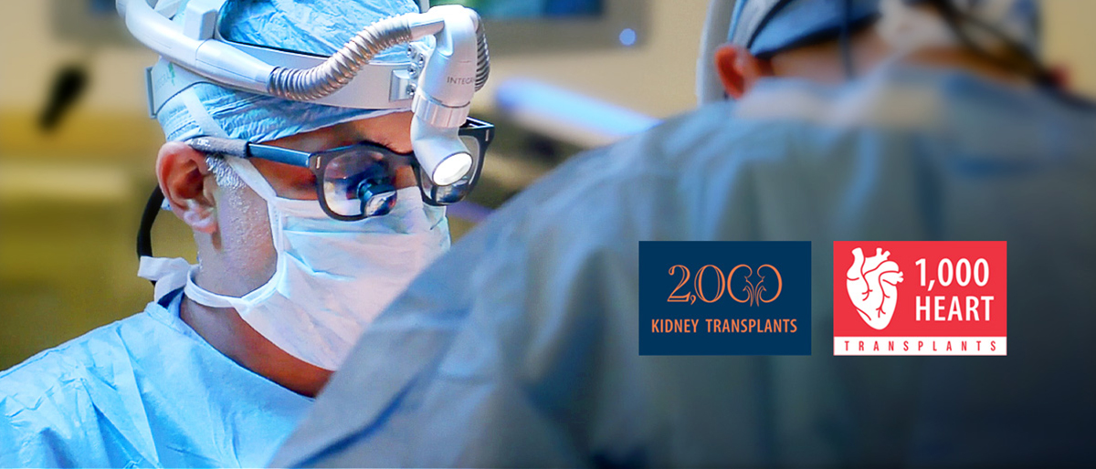 Surgery team in operating room with 2,000 Kidney Transplants logo and 1,000 Heart Transplants logo.