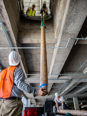 Crews lifted the steel and acrylic poles through the West Campus Building 3 parking garage roof.