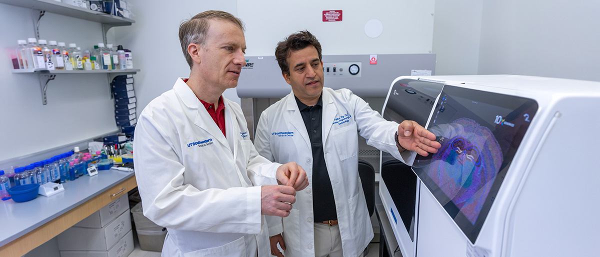 Scientist points out something to collegue on a large machine.