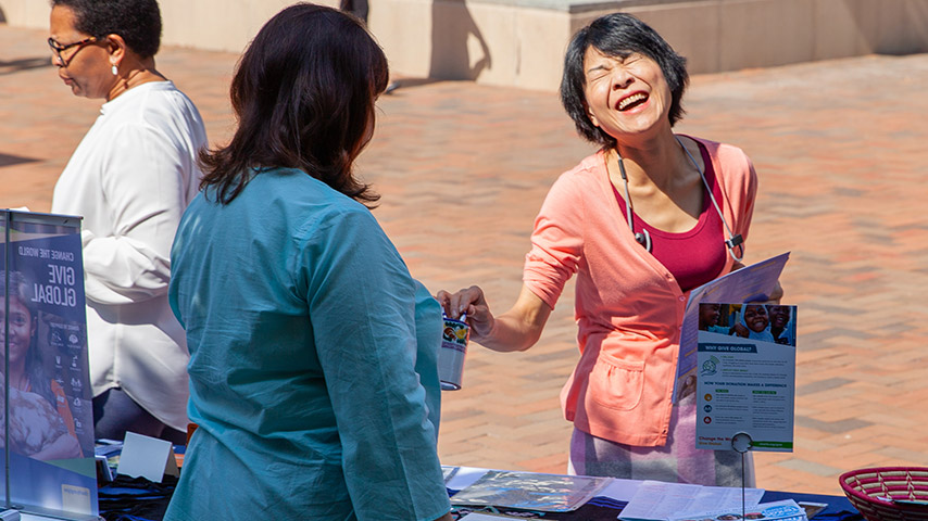 Woman laughing and smiling while donating