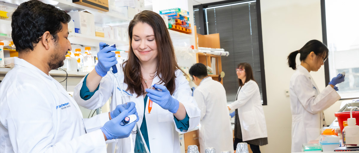 People in lab coats working on equipment