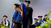 Genetics, Development, and Disease graduate Jordan Wall, Ph.D., receives her hood from Peter Douglas, Ph.D., Associate Professor of Molecular Biology.