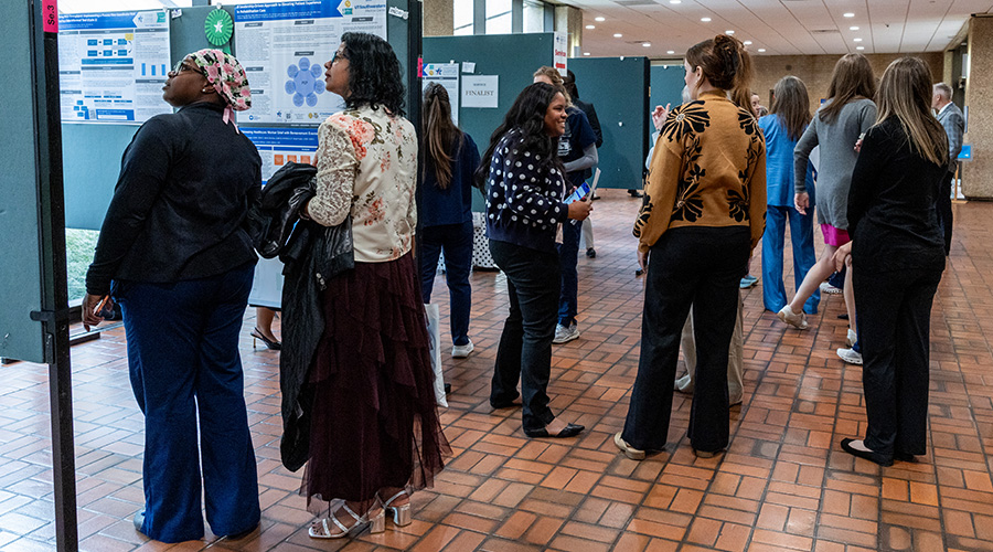 crowd walks thru to read poster presentations outside the Celebration of Excellence event