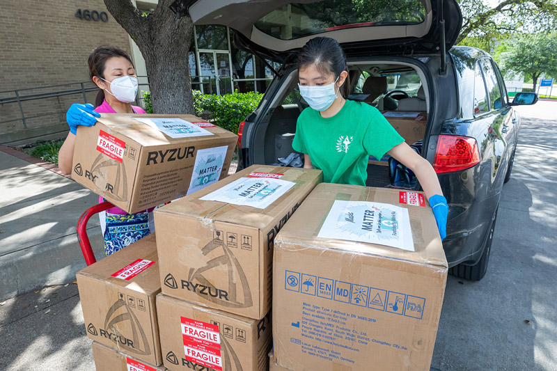 Two women loading boxes onto a cart