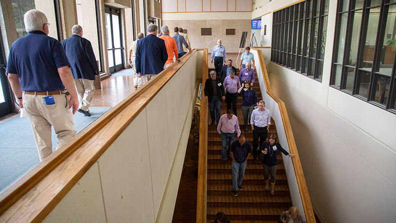 Group of people walking down a hallway and down stairs