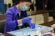 A pharmacist prepares doses of the vaccine.